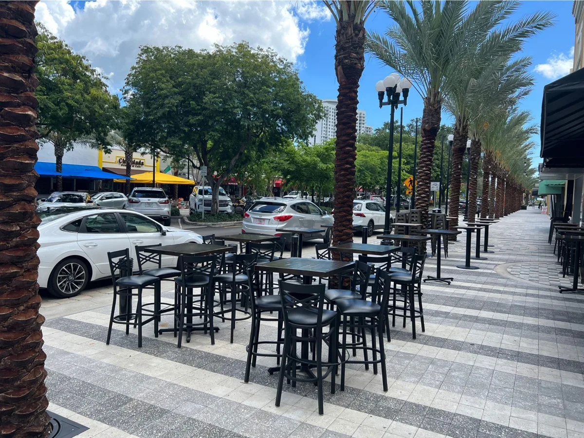 Palm-lined Hollywood Boulevard with outdoor restaurant tables